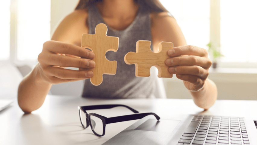 Person placing two puzzle pieces together